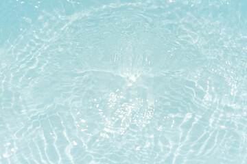 Blue water with ripples on the surface. Defocus blurred transparent blue colored clear calm water surface texture with splashes and bubbles. Water waves with shining pattern texture background.