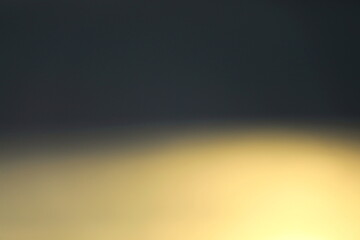 Naklejka premium 夕日に照らされた海の輝きと暗い空をぼかした背景素材