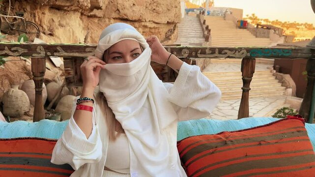 A beautiful girl in traditional clothes rests in a cafe in Egypt