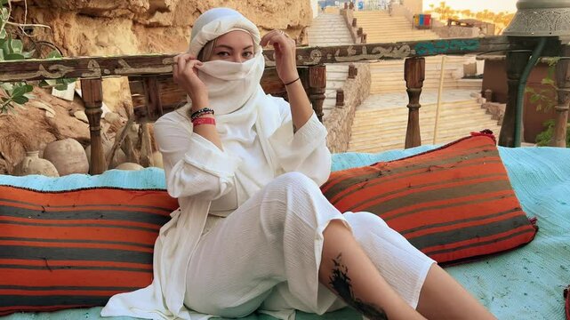 A beautiful girl in traditional clothes rests in a cafe in Egypt