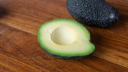 A halved avocado with on a wooden table closeup
