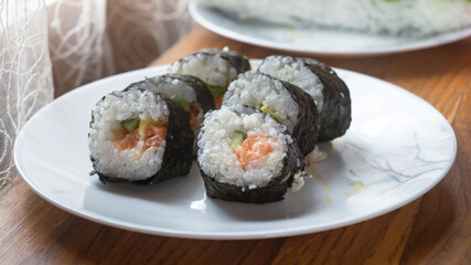 Sliced ​​sushi rolls on a white plate close-up
