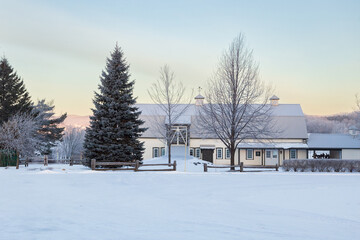 Beautiful large white barn seen during a winter dawn in s snowy landscape, Sainte-Pétronille, Island of Orleans, Quebec