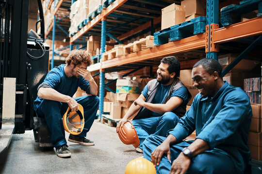 Warehouse workers taking a break and laughing together