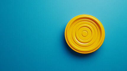 Vibrant yellow circular object on a bright blue background in a creative setting. 