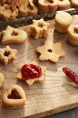Filling traditonal Linzer Christmas cookies with strawberry marmalade