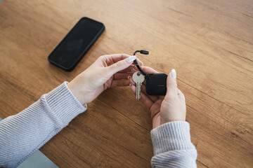 unknown woman hold wireless location accessory token to locate keys