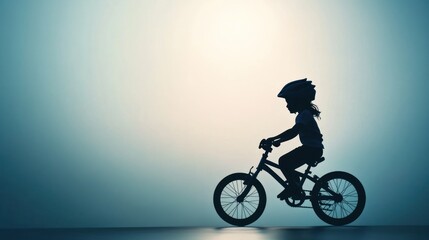 Fototapeta premium Silhouette of child riding bicycle, wearing helmet, outdoors.
