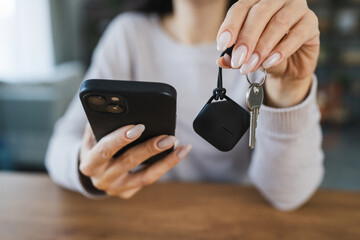 unknown woman hold wireless location accessory token to locate keys