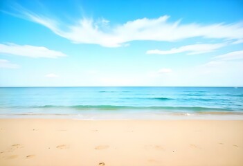 A sandy beach with a clear blue ocean and sky in the background