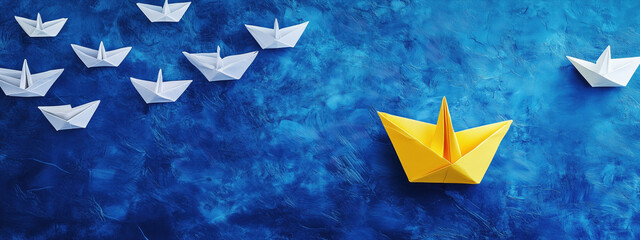 Brightly colored origami boats float across a textured blue surface, showcasing delicate craftsmanship. The vibrant yellow boat stands out among the white ones, creating an engaging visual contrast. 