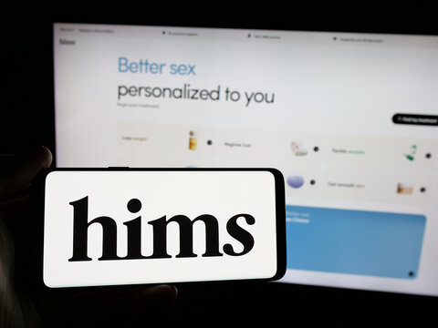 Stuttgart, Germany - 11-27-2024: Person holding smartphone with logo of US telehealth company Hims and Hers Health Inc. on screen in front of website. Focus on phone display.