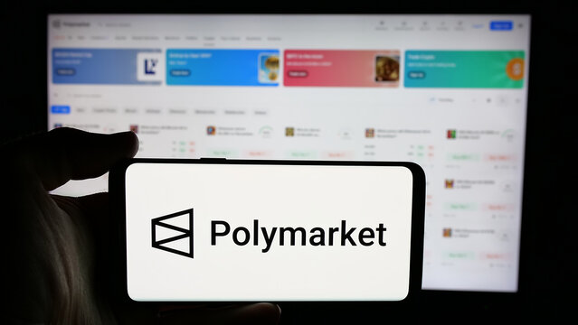 Stuttgart, Germany - 11-27-2024: Person holding cellphone with logo of crypto prediction market company Polymarket on screen in front of business webpage. Focus on phone display.