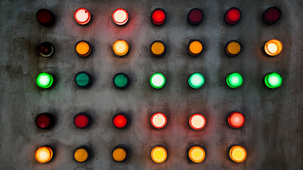 Array of red, green and yellow industrial signal lamp indicators on old and rustic electrical power control center panel