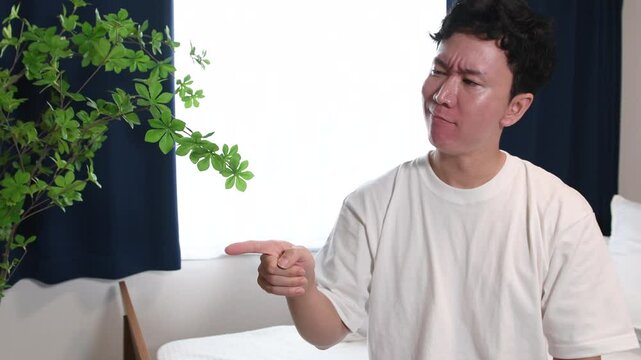 怒っている最中の私服姿の若いアジア人男性