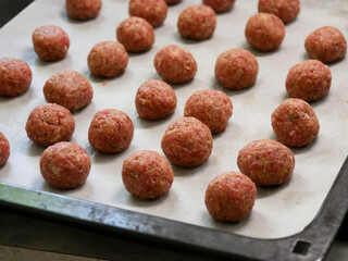 Freshly rolled meatballs, ready to be cooked on the stove. Raw meatballs. Cooking process. Swedish meatballs in the kitchen. Swedish cuisine.