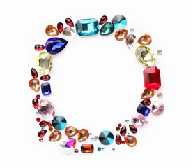 Frame of different shiny gemstones on white background, flat lay. Space for text