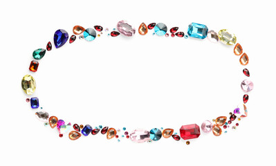 Frame of different shiny gemstones on white background, flat lay. Space for text