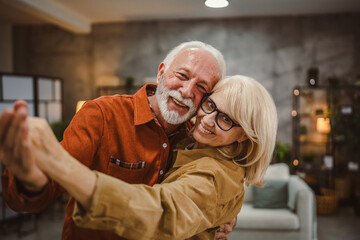 senior couple husband and wife love dance and hug at home have fun