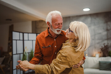 senior couple husband and wife love dance and hug at home have fun