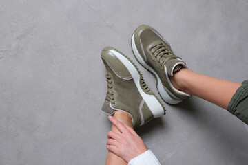 Comfortable khaki color sneakers on female legs