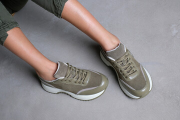 Comfortable khaki color sneakers on female legs