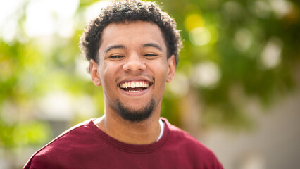 Happy man smiling outdoors with green background