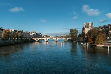 Fototapeta premium A stunning bridge over water with buildings in the background. Paris, France