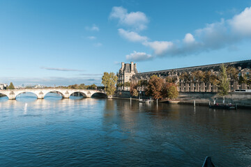 A picturesque and scenic view showcasing The Louvre Museum situated beautifully by the River Seine....