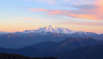 Fototapeta premium mountains with a snow covered peak in the distance at sunset