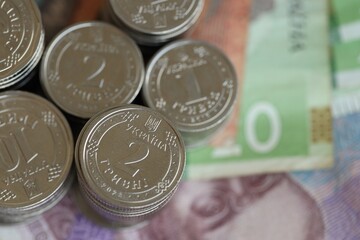 Few stacks of ukrainian money coins lies on old hryvnia banknotes