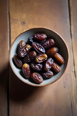 A tiny bowl of dates on a wooden table old