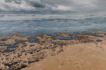 Oil leaked in coastline after a tanker wreck. Oil fuel polluted and destroy beach