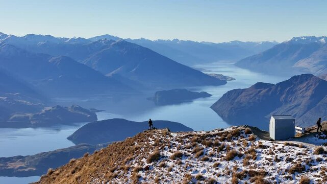 Aerial view of a man standing on the edge of a mountain in Wanaka, New Zealand
