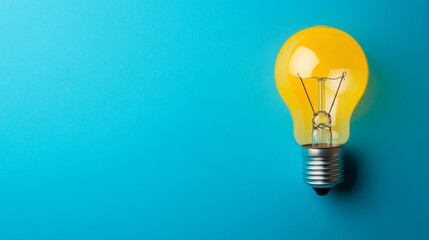 A bright yellow light, stunning, background bulb against a blue background, symbolizing ideas and innovation.