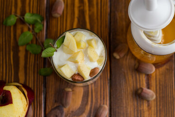 sweet homemade yogurt in a glass with apples, nuts and honey