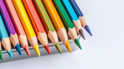 Fototapeta premium Brightly Colored Pencils Laid Out Neatly on a Silver Metal Tin with a White Background, Perfect for Art, Drawing, and Creative Projects