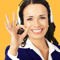 Portrait image of happy smiling cheerful corporate customer support phone operator in headset...