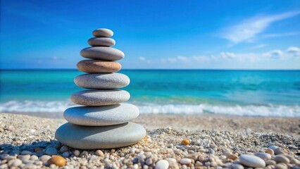 Fototapeta premium A Stack of Smooth Stones on a Sandy Beach with a Blurred Ocean in the Background