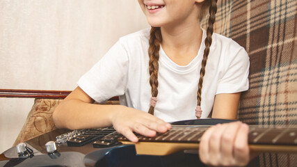 Girl playing electric guitar and practicing at home