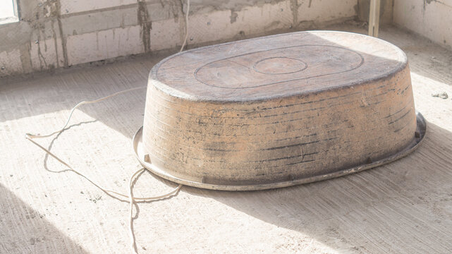 A plastic cement pickup truck lies face down on the ground in a construction site. End of work concept