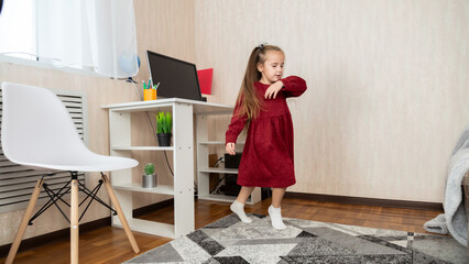 Little girl in red dress dancing at home