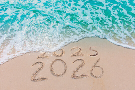 Message Year 2025 replaced by 2026 text written on beach sand background. Good bye 2025 - 2026 happy New Year coming concept.  top view.