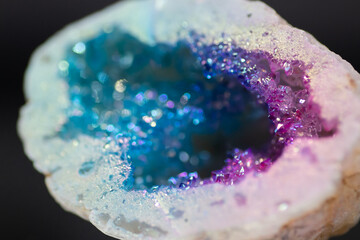 A natural electroplated agate crystal, beautifully polished and isolated in a studio, displays vibrant, iridescent hues with shimmering details