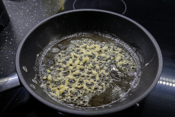 minced garlic frying in bubbling butter in a nonstick pan, creating a golden and aromatic base for cooking