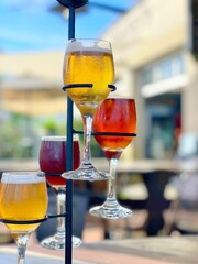 Bright and colorful beer or wine flight in a spiraling display set against a sunny and tropical brewery background. 