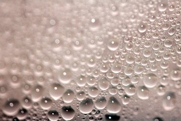 Close Up of Condensation Floating Liquid Water Bubbles and Drips on Glass from Rain