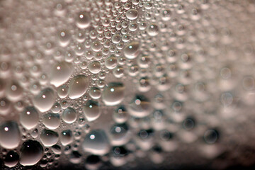 Close Up of Condensation Floating Liquid Water Bubbles and Drips on Glass from Rain