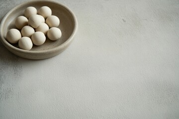 set of handmade clay beads scattered on smooth gray ceramic surface