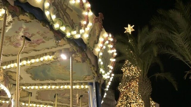 Close-up of a carousel spinning with a Christmas tree in the background